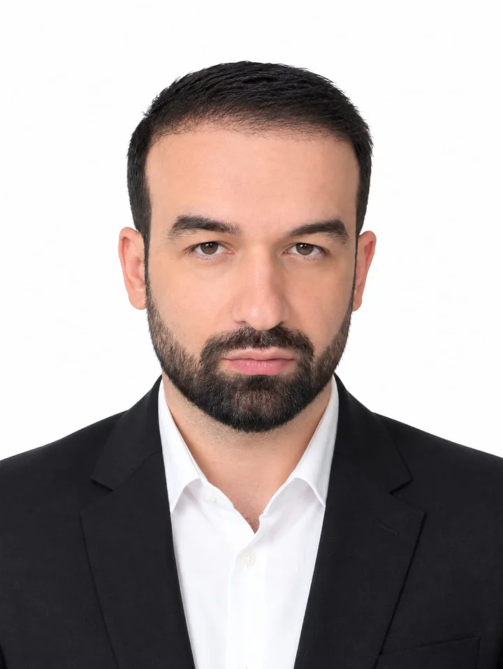 Furkan Tortçu'nun portresi: koyu takım elbise ve beyaz gömlek